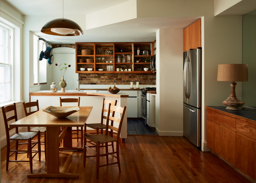 This is an example of a mid-sized midcentury kitchen/dining combo in Boston with white walls and light hardwood floors.