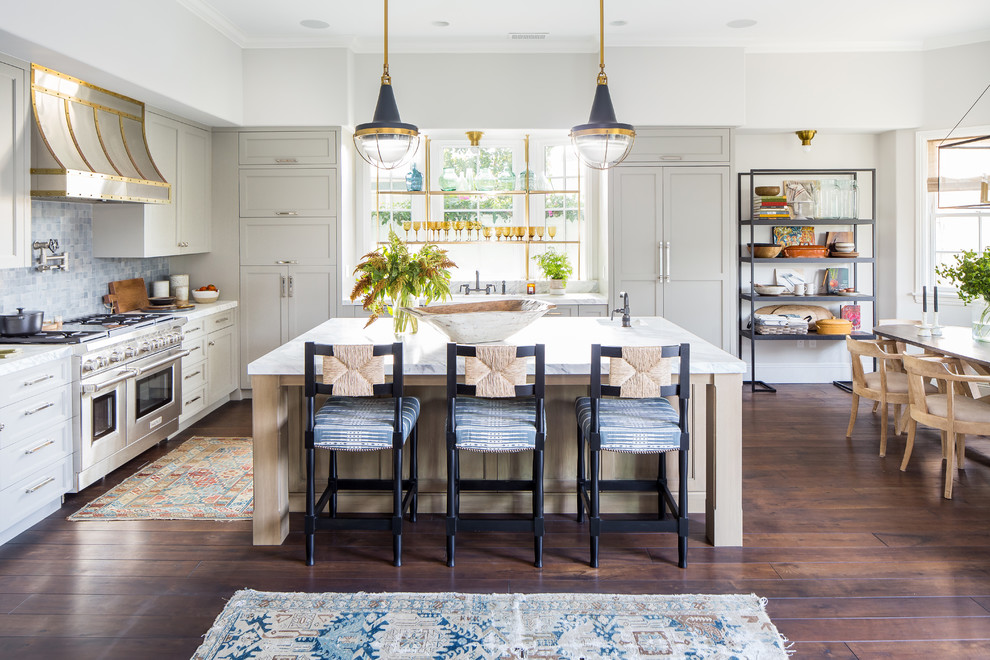 Country l-shaped eat-in kitchen in Los Angeles with recessed-panel cabinets, white cabinets, blue splashback, mosaic tile splashback, stainless steel appliances, dark hardwood floors, with island, brown floor and white benchtop.