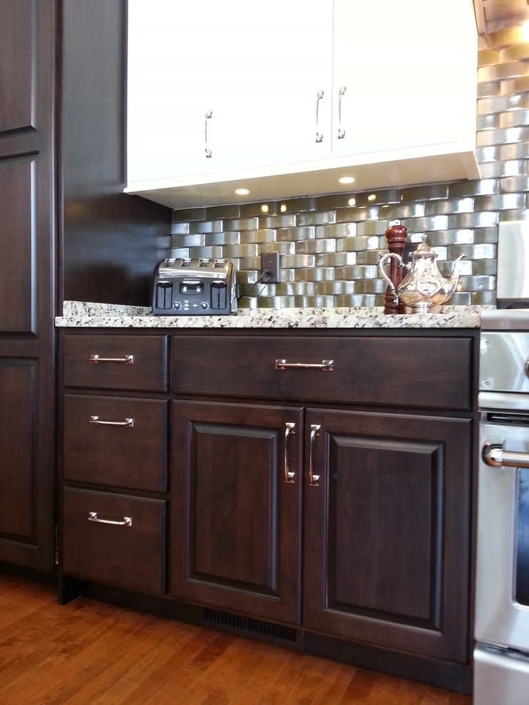 Mid-sized transitional galley dark wood floor and brown floor eat-in kitchen photo with raised-panel cabinets, dark wood cabinets, granite countertops, metallic backsplash and stainless steel appliances