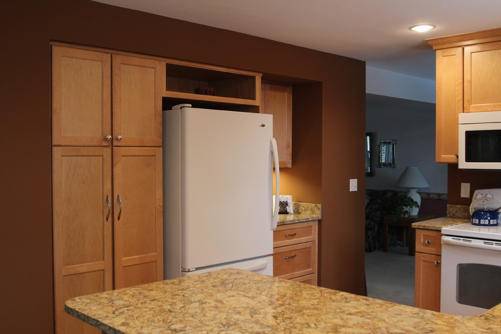 Eat-in kitchen - small transitional u-shaped medium tone wood floor eat-in kitchen idea in Denver with an undermount sink, shaker cabinets, light wood cabinets, quartz countertops, brown backsplash, white appliances and a peninsula