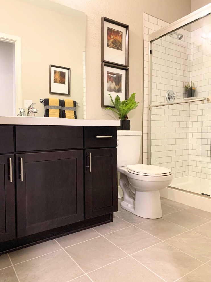 Design ideas for a small contemporary 3/4 bathroom in Denver with shaker cabinets, dark wood cabinets, a shower/bathtub combo, white tile, ceramic tile, beige walls, porcelain floors, an undermount sink, laminate benchtops, grey floor, a sliding shower screen and white benchtops.