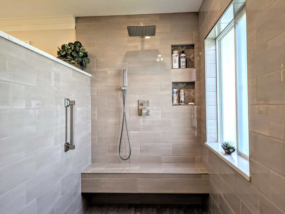 Пример оригинального дизайна: главная ванная комната среднего размера с фасадами с утопленной филенкой, серыми фасадами, открытым душем, унитазом-моноблоком, коричневой плиткой, плиткой кабанчик, бежевыми стенами, полом из керамической плитки, врезной раковиной, столешницей из искусственного кварца, коричневым полом, открытым душем, белой столешницей, сиденьем для душа, тумбой под две раковины и встроенной тумбой