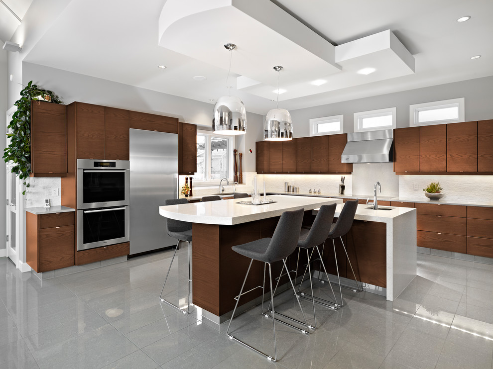 Inspiration for a contemporary l-shaped kitchen in Edmonton with an undermount sink, flat-panel cabinets, dark wood cabinets, white splashback, stainless steel appliances, multiple islands and grey floor.