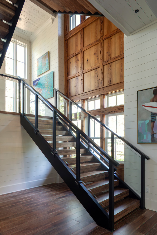 Design ideas for a large coastal wood u-shaped metal railing staircase in Other with wood risers and panelled walls.