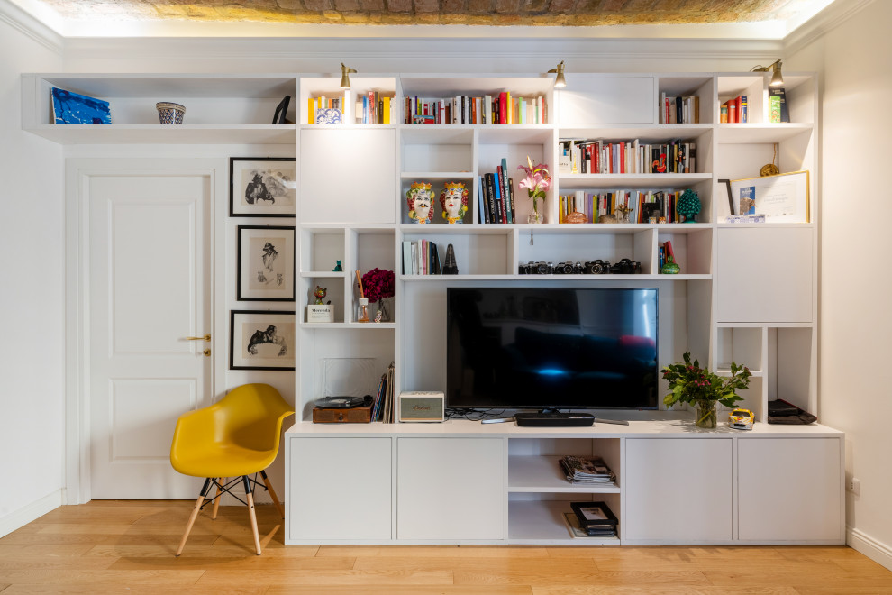 Imagen de sala de estar con biblioteca abierta contemporánea grande sin chimenea con paredes blancas, suelo de madera clara, pared multimedia y suelo beige