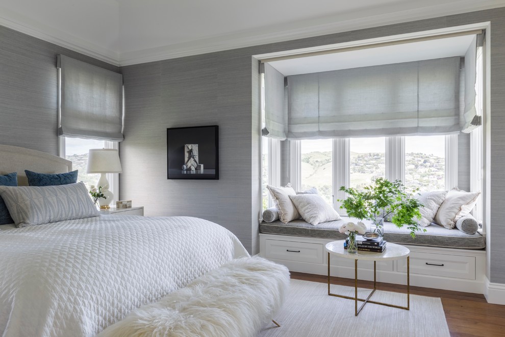 Example of a transitional medium tone wood floor and brown floor bedroom design in San Francisco with gray walls