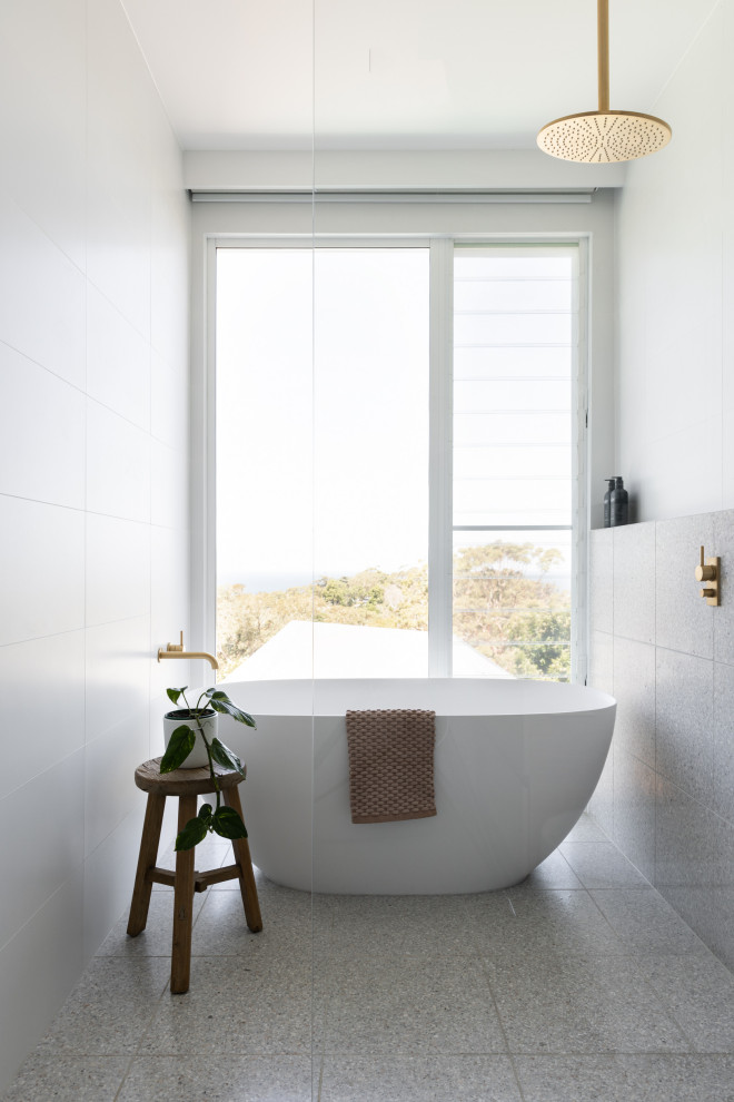 Idéer för ett modernt vit badrum, med släta luckor, bruna skåp, ett fristående badkar, en dusch/badkar-kombination, en toalettstol med hel cisternkåpa, vit kakel, cementkakel, vita väggar, terrazzogolv, grått golv och med dusch som är öppen