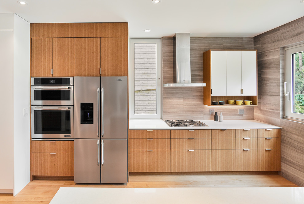 Inspiration for a contemporary galley kitchen in Toronto with an undermount sink, flat-panel cabinets, light wood cabinets, quartz benchtops, grey splashback, stone tile splashback, stainless steel appliances and light hardwood floors.