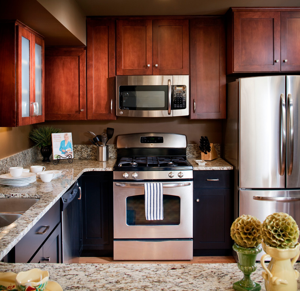 Inspiration for a mid-sized transitional u-shaped light wood floor eat-in kitchen remodel in Omaha with a double-bowl sink, shaker cabinets, dark wood cabinets, stainless steel appliances, granite countertops, beige backsplash, stone slab backsplash and a peninsula