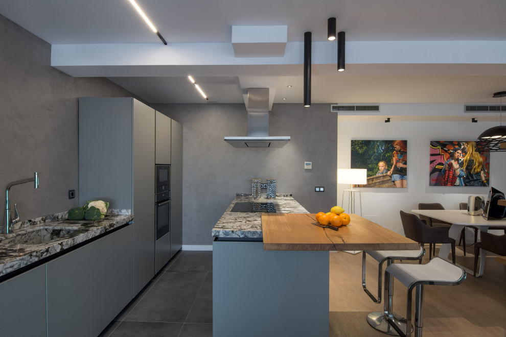 Idee per una cucina moderna di medie dimensioni con lavello integrato, ante grigie, top in granito, elettrodomestici neri e top grigio