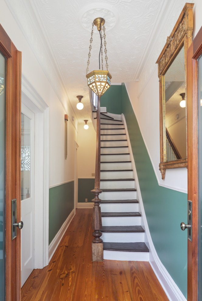 Mid-sized traditional foyer in New York with white walls, medium hardwood floors, a double front door, a medium wood front door, brown floor and decorative wall panelling.