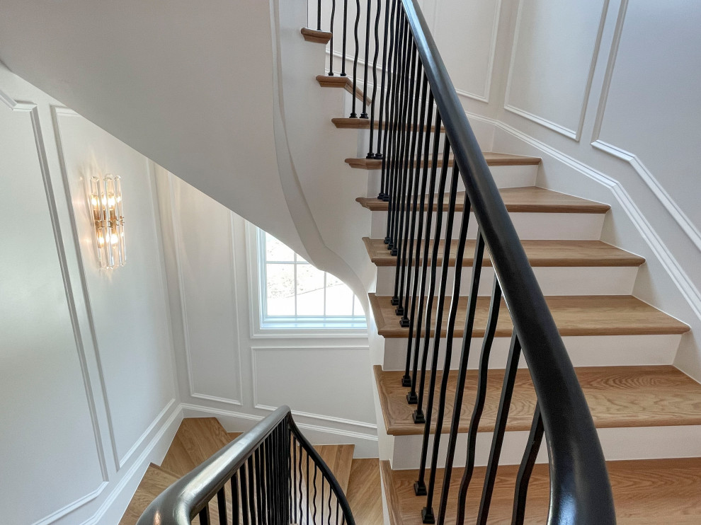 Inspiration for a large classic wood floating mixed railing staircase in DC Metro with painted wood risers and wainscoting.