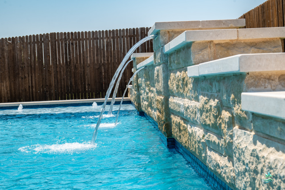 Ispirazione per una piscina monocorsia american style rettangolare di medie dimensioni e dietro casa con paesaggistica bordo piscina e lastre di cemento