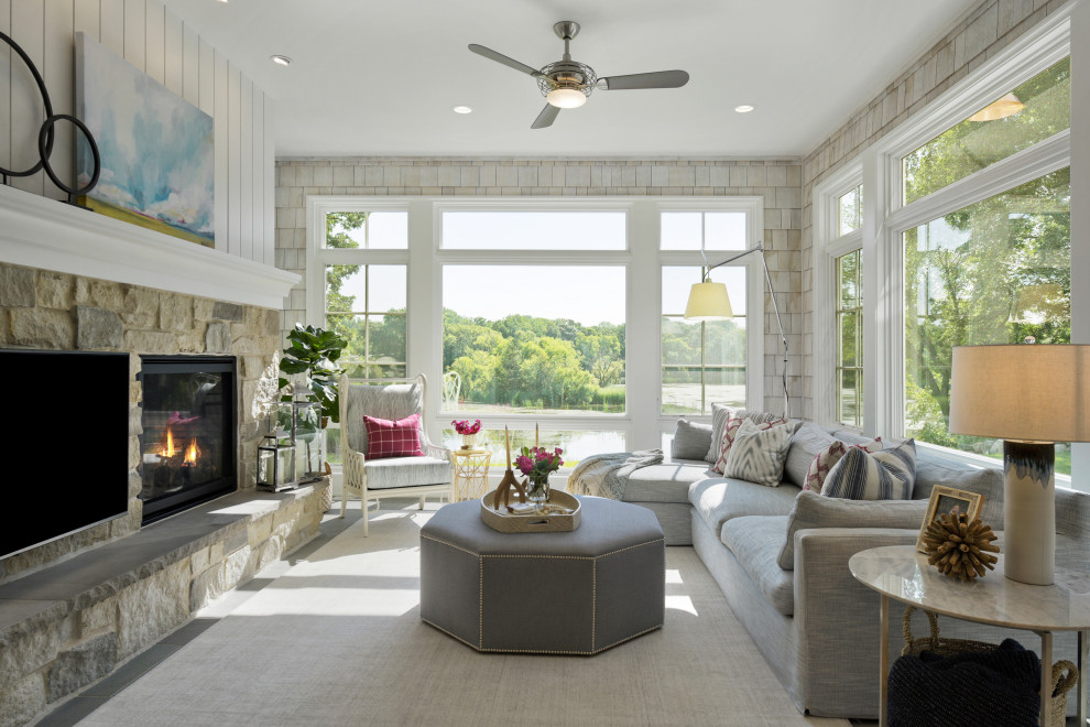 This is an example of a beach style sunroom in Minneapolis with a standard fireplace, a stone fireplace surround and a standard ceiling.