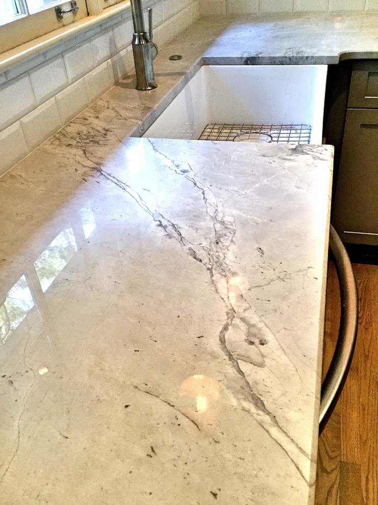 Inspiration for a mid-sized rustic u-shaped light wood floor open concept kitchen remodel in Atlanta with a farmhouse sink, shaker cabinets, gray cabinets, quartzite countertops, white backsplash, subway tile backsplash, stainless steel appliances and a peninsula