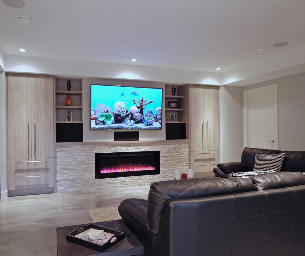 Photo of a large modern open concept home theatre in Calgary with grey walls, concrete floors, a wall-mounted tv and grey floor.