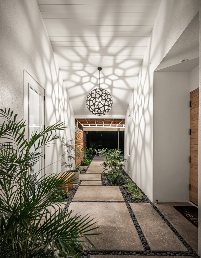 Ispirazione per un corridoio design di medie dimensioni con pareti bianche, pavimento in cemento, una porta singola, una porta in legno chiaro, pavimento grigio e soffitto in perlinato