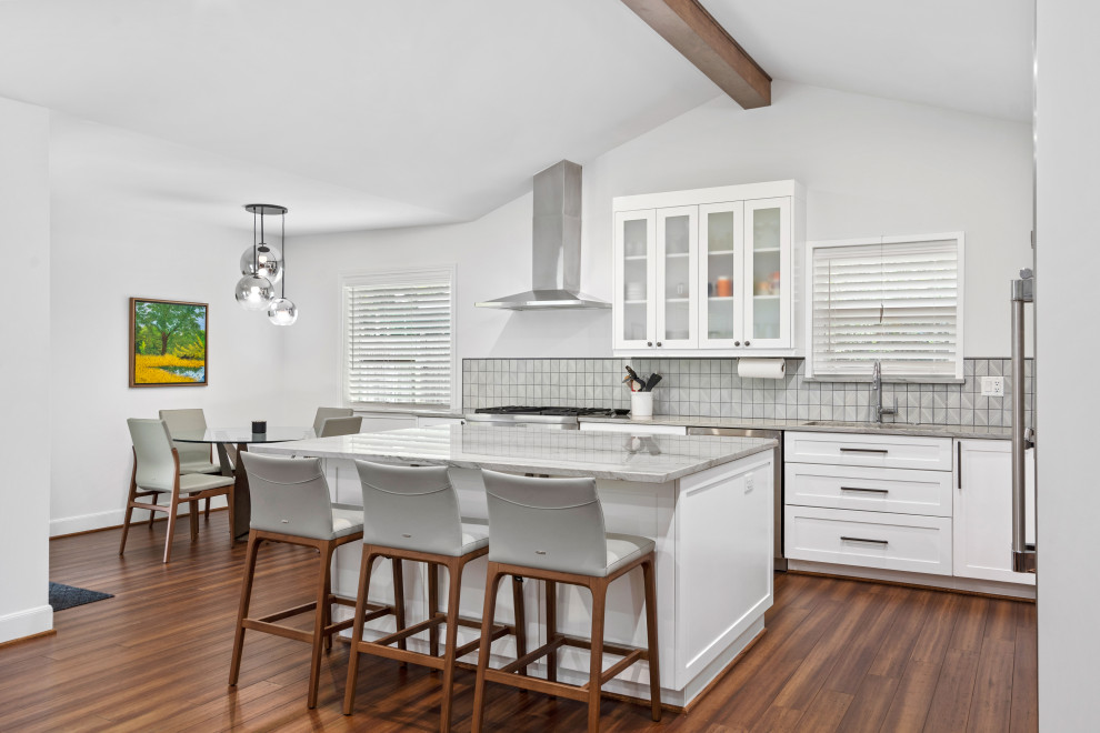 Design ideas for a medium sized midcentury l-shaped kitchen/diner in Houston with shaker cabinets, white cabinets, quartz worktops, bamboo flooring, an island, brown floors, grey worktops and a vaulted ceiling.