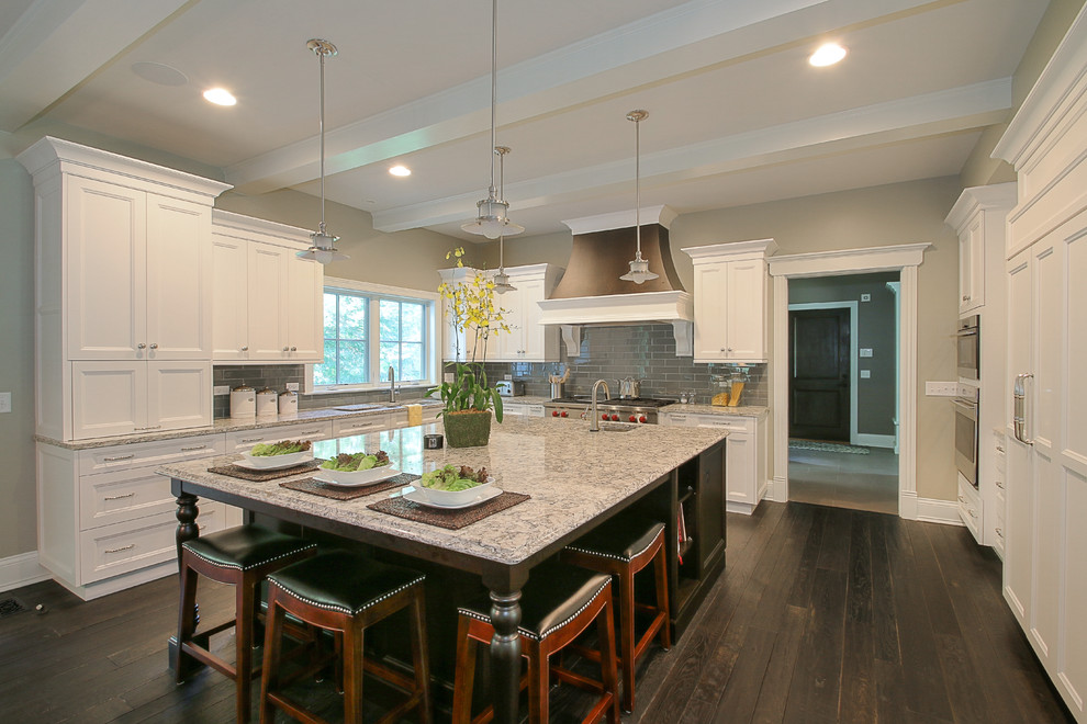 Inspiration for a large transitional u-shaped dark wood floor and brown floor kitchen remodel in Chicago with an island, an undermount sink, recessed-panel cabinets, white cabinets, granite countertops, gray backsplash, subway tile backsplash and stainless steel appliances
