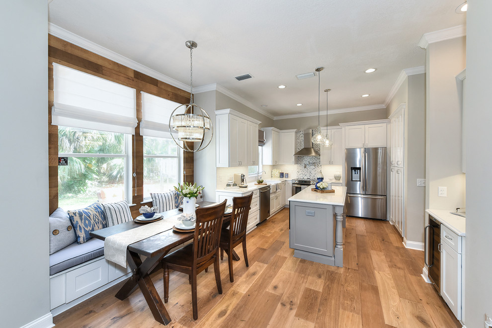 Large transitional l-shaped medium tone wood floor eat-in kitchen photo in Jacksonville with a farmhouse sink, shaker cabinets, quartz countertops and an island