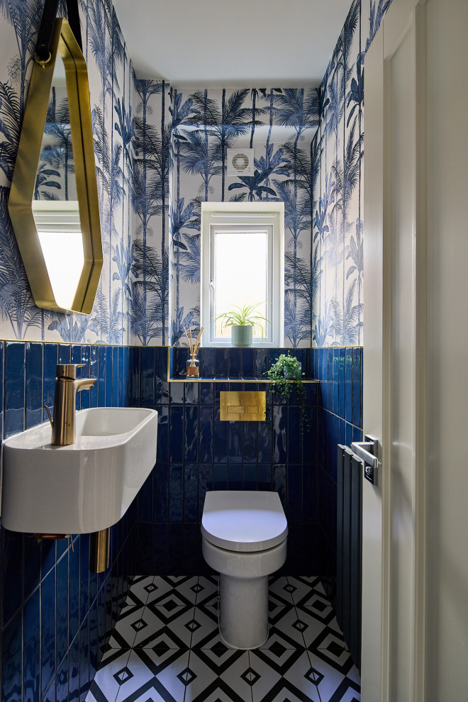 Imagen de cuarto de baño único contemporáneo pequeño con sanitario de una pieza, baldosas y/o azulejos azules, baldosas y/o azulejos de porcelana, paredes azules, suelo de baldosas de porcelana, lavabo suspendido, suelo negro, cuarto de baño y papel pintado