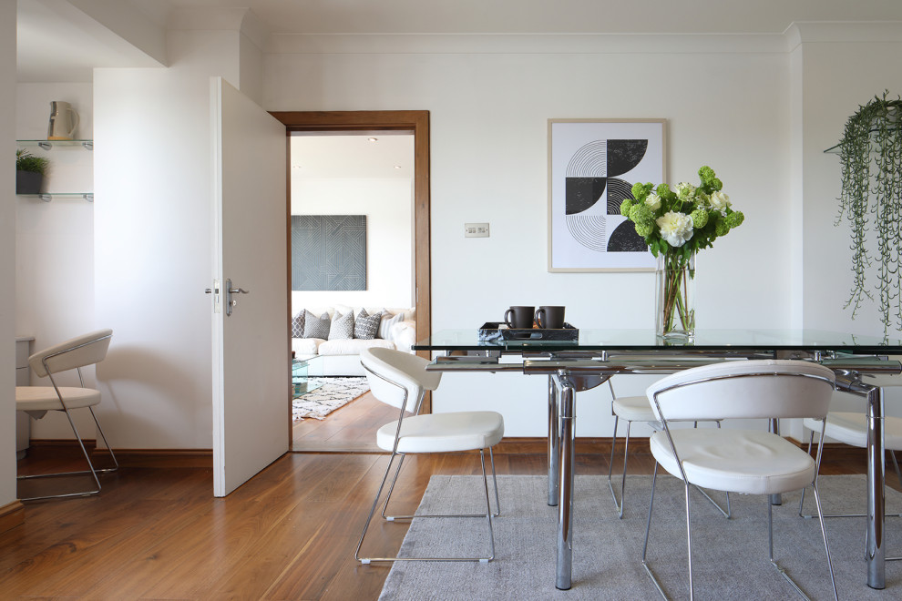 Immagine di una grande sala da pranzo aperta verso il soggiorno minimalista con pareti bianche, parquet scuro e pavimento marrone