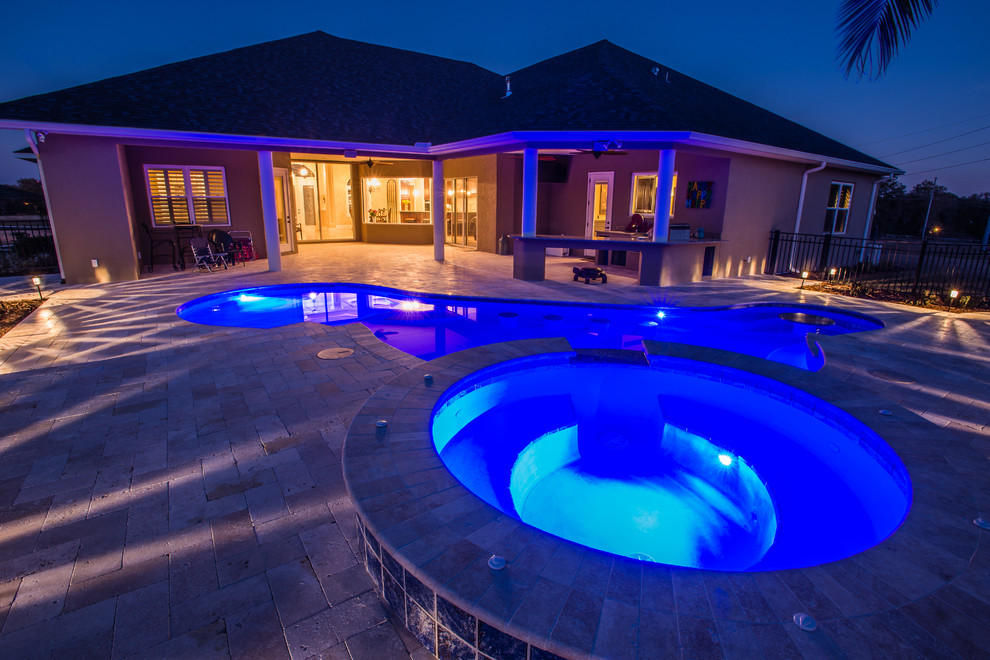 Inspiration for a mid-sized transitional backyard brick and custom-shaped lap hot tub remodel in Orlando