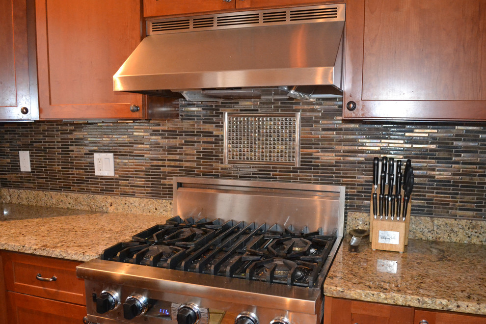 Kitchen - mid-sized transitional kitchen idea with shaker cabinets, dark wood cabinets, granite countertops, multicolored backsplash, matchstick tile backsplash and stainless steel appliances