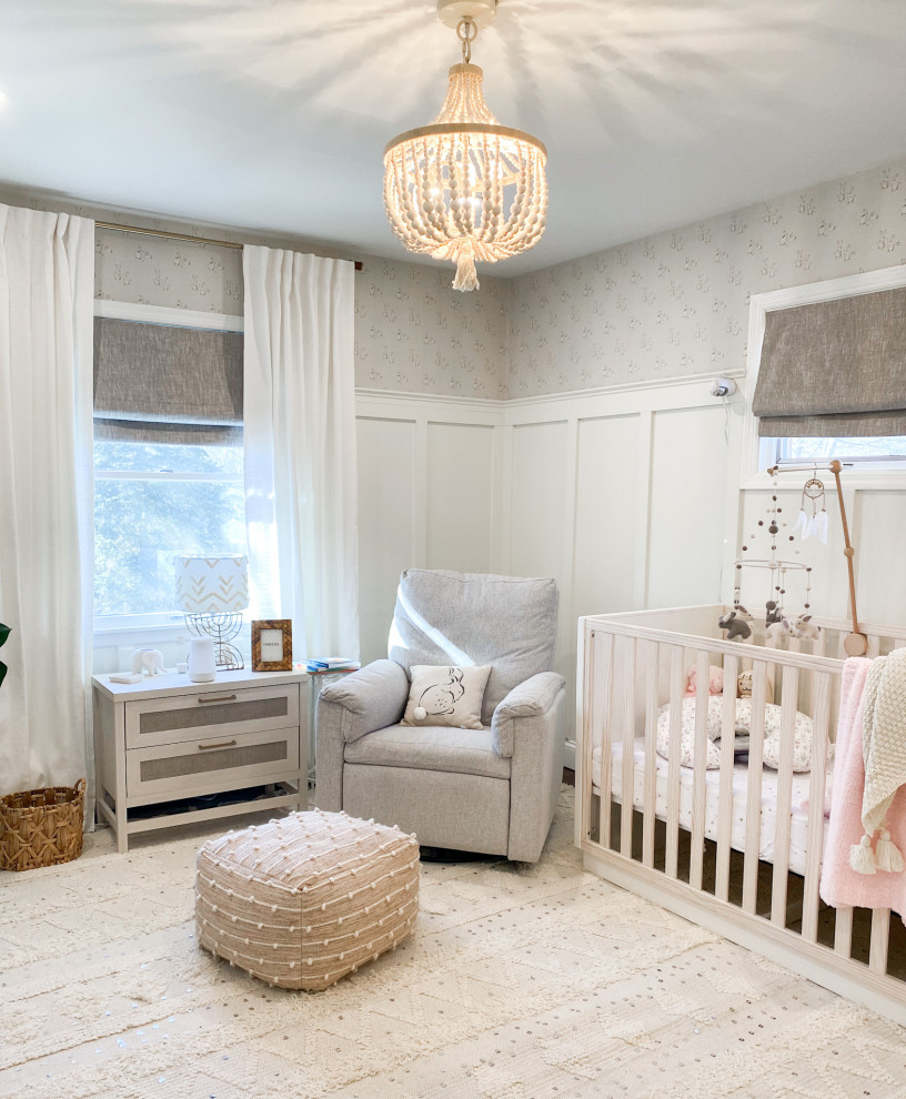 Medium sized shabby-chic style nursery for girls in New York with white walls, medium hardwood flooring, brown floors and wallpapered walls.