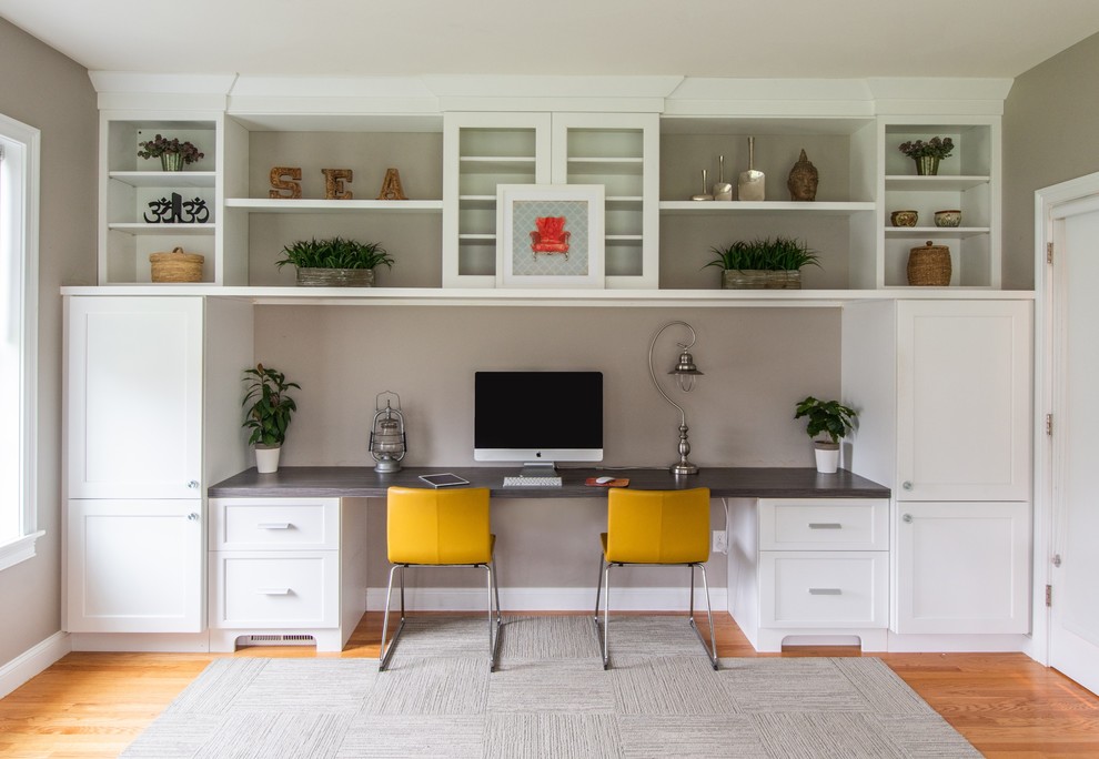 Inspiration for a mid-sized transitional home office in Boston with a built-in desk, brown floor, grey walls and medium hardwood floors.