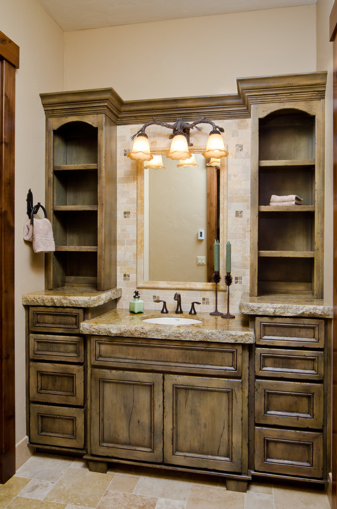 This is an example of a large country kids bathroom in Other with an undermount sink, furniture-like cabinets, distressed cabinets, granite benchtops, mosaic tile, beige walls, travertine floors, beige tile, beige floor and grey benchtops.