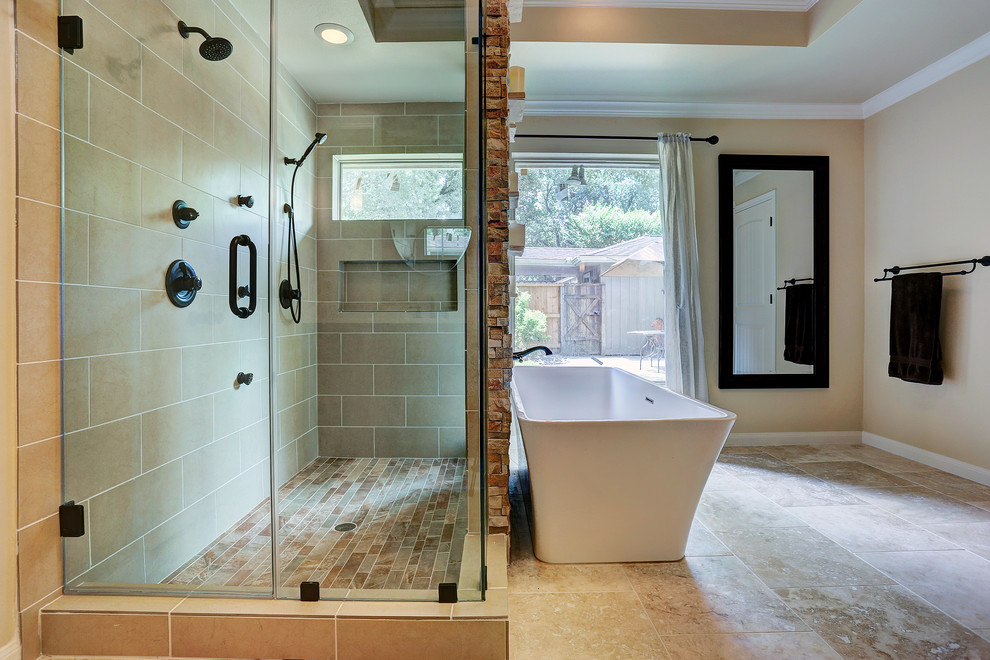 Photo of a large arts and crafts master bathroom in Houston with a drop-in sink, recessed-panel cabinets, dark wood cabinets, marble benchtops, a freestanding tub, an open shower, a one-piece toilet, beige tile, stone slab, beige walls and travertine floors.