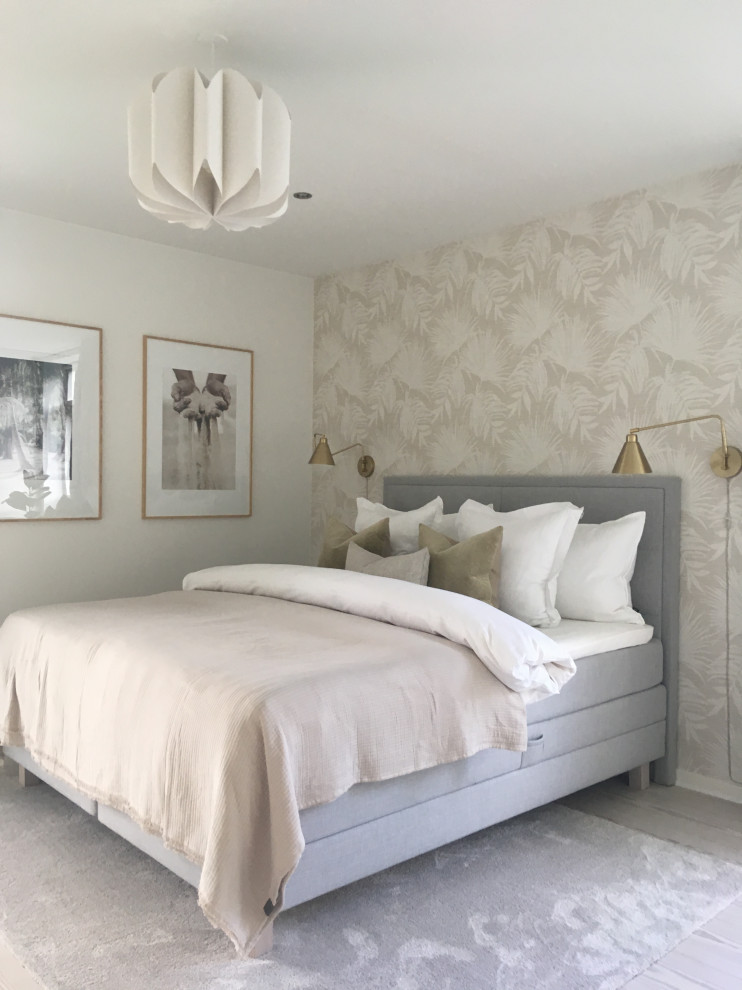 Imagen de dormitorio principal exótico grande con paredes beige, suelo de madera clara y papel pintado
