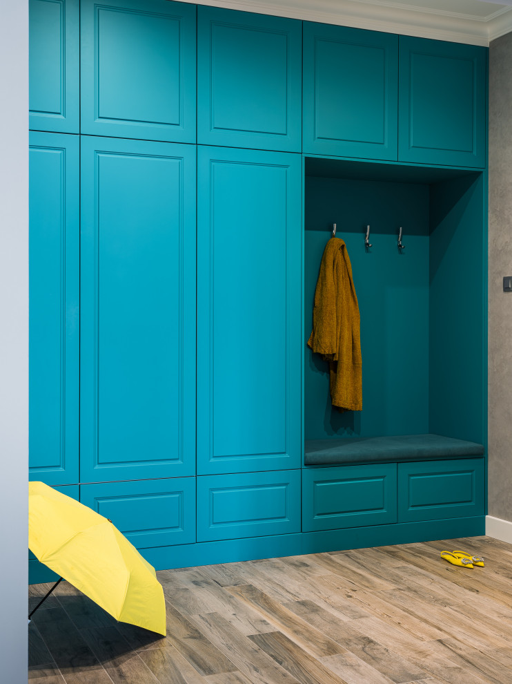Пример оригинального дизайна: входная дверь среднего размера: освещение с синими стенами, полом из керамогранита, одностворчатой входной дверью, белой входной дверью и серым полом