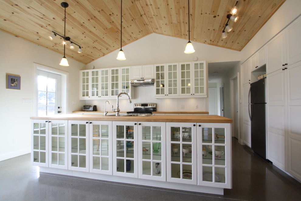 Mid-sized transitional galley concrete floor and brown floor open concept kitchen photo in Toronto with a double-bowl sink, glass-front cabinets, white cabinets, wood countertops, white backsplash, stainless steel appliances, an island and wood backsplash