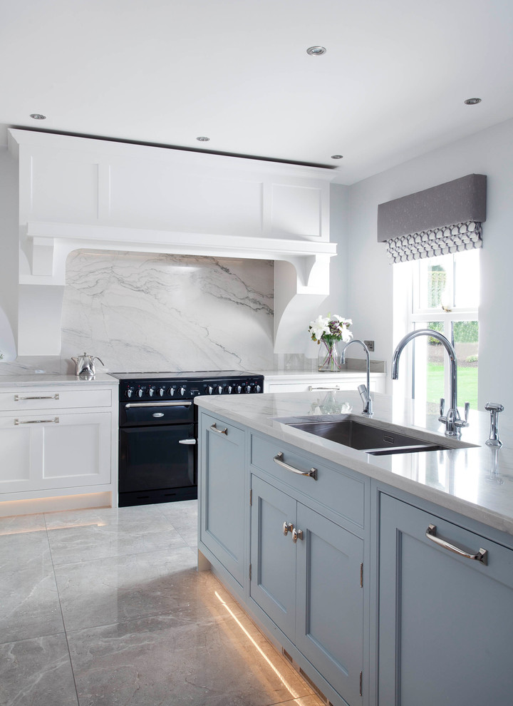 Mid-sized transitional l-shaped open plan kitchen in Other with an integrated sink, shaker cabinets, blue cabinets, marble benchtops, grey splashback, marble splashback, stainless steel appliances, porcelain floors, with island and grey floor.