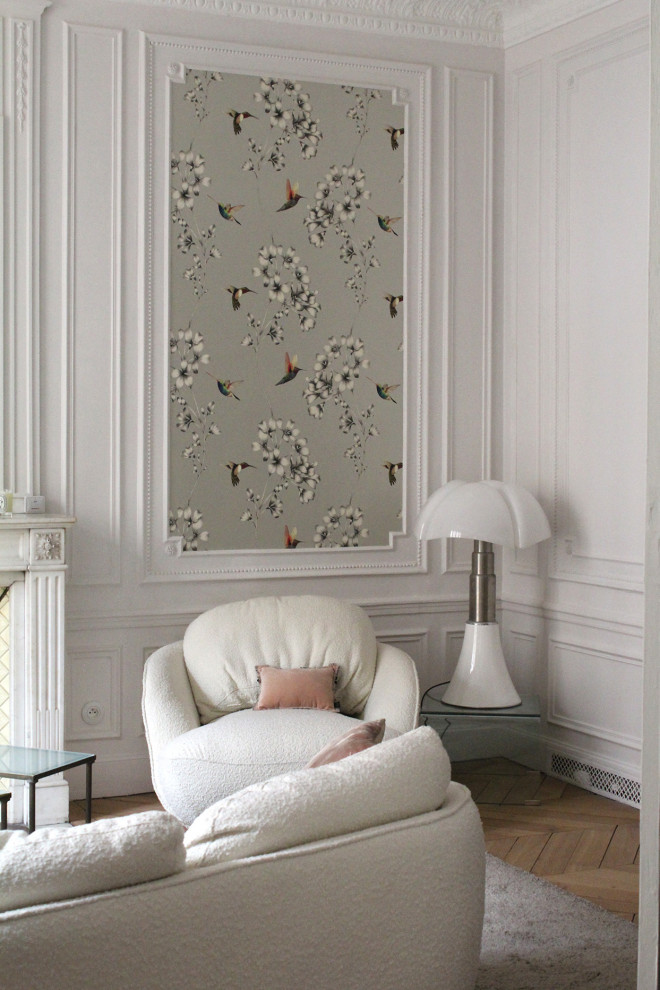 パリにある中くらいなトラディショナルスタイルのおしゃれな独立型リビング (白い壁、淡色無垢フローリング、標準型暖炉、据え置き型テレビ、壁紙) の写真