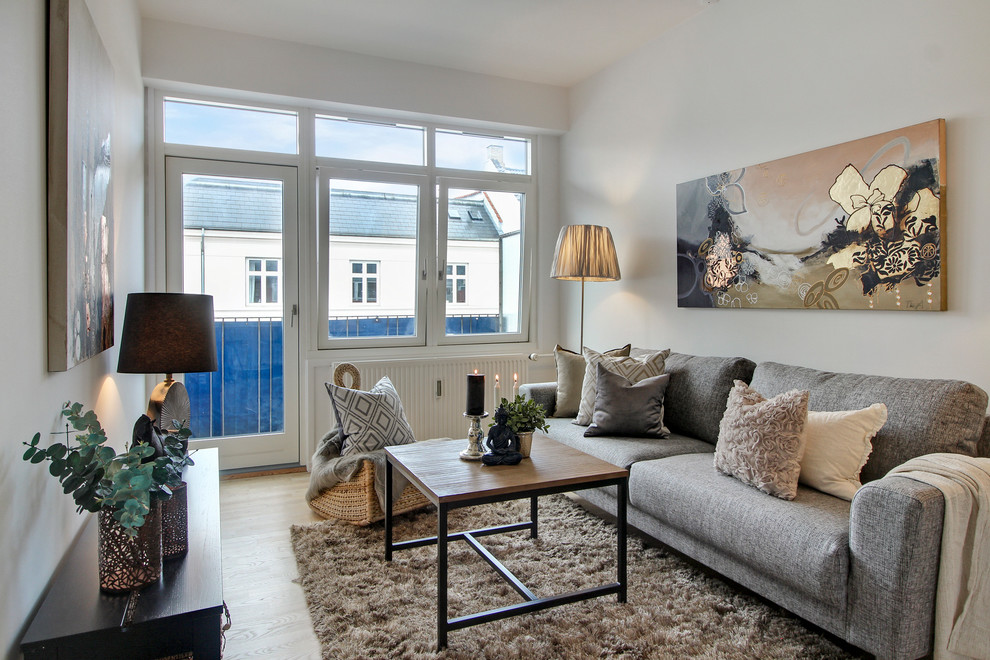 This is an example of a small transitional enclosed living room in Copenhagen with white walls, light hardwood floors and beige floor.