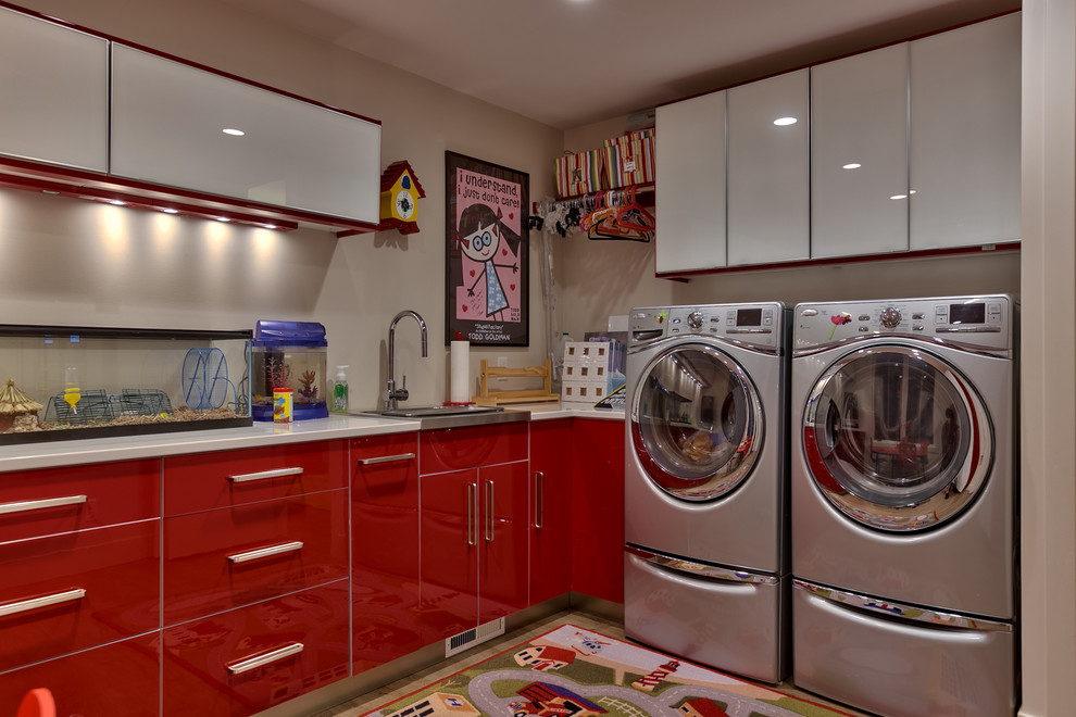 Inspiration for a contemporary l-shaped laundry room in Omaha with a drop-in sink, flat-panel cabinets, red cabinets, beige walls and a side-by-side washer and dryer.