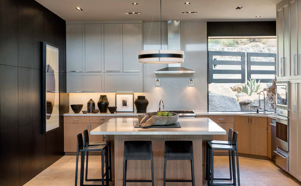 This is an example of a contemporary kitchen in Phoenix with an undermount sink, flat-panel cabinets, light wood cabinets, grey splashback, stainless steel appliances, with island, beige floor and grey benchtop.