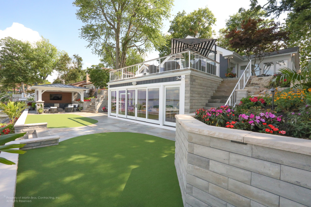 Immagine di un grande patio o portico costiero dietro casa con pavimentazioni in pietra naturale e un gazebo o capanno