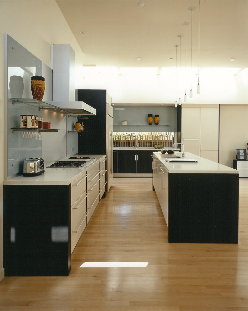 This is an example of a contemporary galley kitchen in Other with flat-panel cabinets, white cabinets and glass sheet splashback.