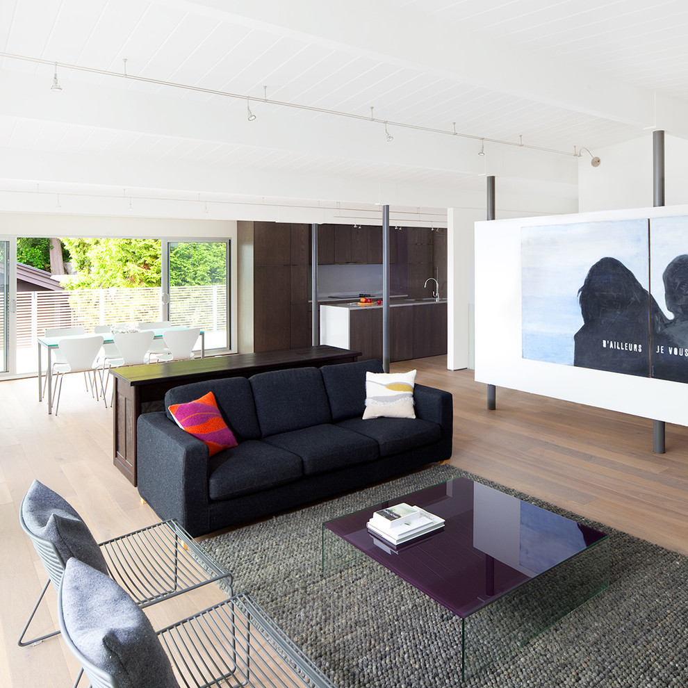 This is an example of a modern open concept living room in Vancouver with white walls.