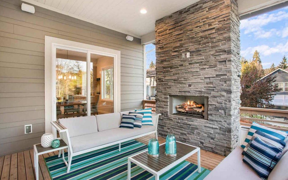 Design ideas for a contemporary deck in Seattle with with fireplace and a roof extension.