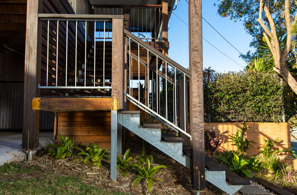 Photo of a large contemporary wood l-shaped staircase in Brisbane with wood risers and mixed railing.