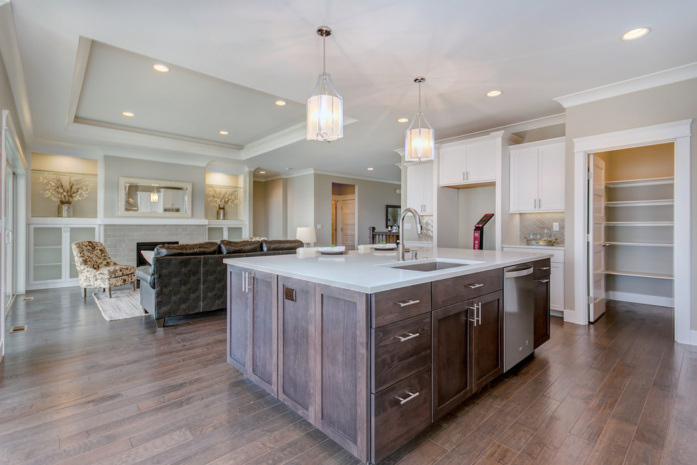Inspiration for a large transitional l-shaped dark wood floor open concept kitchen remodel in Seattle with an undermount sink, shaker cabinets, white cabinets, quartz countertops, gray backsplash, porcelain backsplash, stainless steel appliances, an island and white countertops