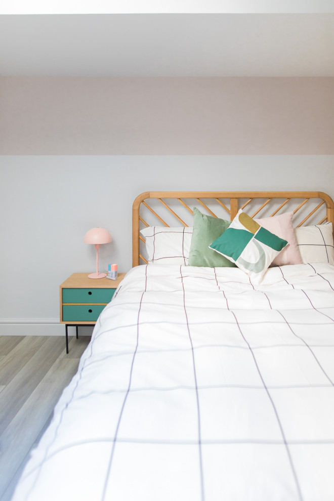 Inspiration for a small contemporary guest and grey and pink bedroom in Sussex with white walls, light hardwood flooring, grey floors and feature lighting.