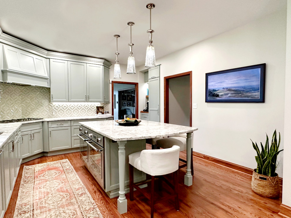 Inspiration for a transitional l-shaped medium tone wood floor eat-in kitchen remodel with shaker cabinets, green cabinets, quartzite countertops, porcelain backsplash, paneled appliances and an island