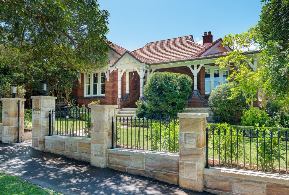 Mid-sized traditional two-story brick and shingle exterior home idea in Sydney with a tile roof and a red roof