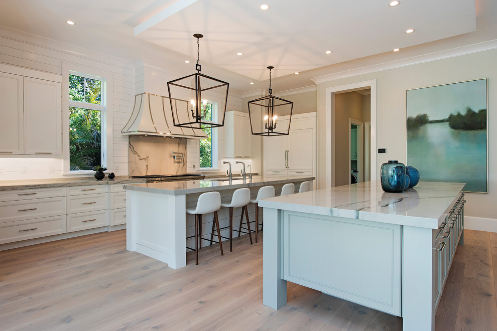 Example of a transitional eat-in kitchen design in Miami with a double-bowl sink, shaker cabinets, white cabinets, stainless steel appliances and two islands